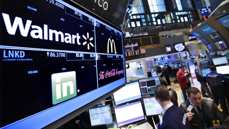 File photo of a board showing stock prices for Walmart, Linkedin, McDonald's and Coca-Cola at a booth on the floor of the New York Stock Exchange